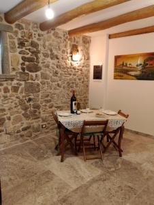 ein Esszimmer mit einem Tisch und einer Flasche Wein in der Unterkunft La medievale 1 in Pignone