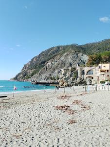 a sandy beach with a building and the ocean at La medievale 1 in Pignone