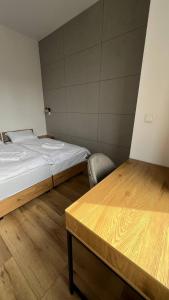 um quarto com uma cama, uma mesa e uma cadeira em CityCenterApartments/M32/8B em Bielsko-Biala