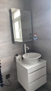 a white bathroom with a sink and a mirror at nana house in London