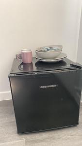 a plate and a cup on top of a washing machine at nana house in London