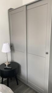 1 dormitorio con armarios blancos y mesa con lámpara en nana house, en Londres