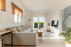 Una sala de estar con un sofá y un televisor. en Villa Carpe Diem - 2BR - 300m to Beach, en Heraklion