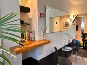 a room with a mirror and a table and chairs at Dizengoff 208 Hotel Tel Aviv in Tel Aviv
