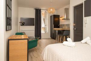 um quarto com duas camas e uma mesa e uma cozinha em Grand studio industriel dans le centre historique em Poitiers