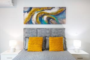 ein Schlafzimmer mit einem Bett mit zwei gelben Kissen in der Unterkunft Kasino II 1º A in Monte Gordo