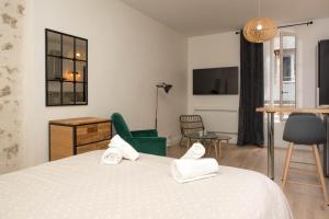 um quarto com uma cama, uma cadeira e uma mesa em Grand studio industriel dans le centre historique em Poitiers