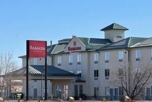 a large building with a sign in front of it at Ramada by Wyndham Estevan in Estevan