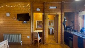 um quarto com uma cozinha e um lavatório numa casa em Blossom Cabin - Little log Cabin in Wales em Newtown