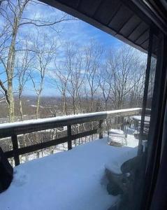 a snow covered porch with a view of the mountains at Stylish Townhouse Steps to Ski Mtn & Waterpark in Tannersville