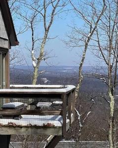 a wooden bench sitting on top of a balcony with a view at Stylish Townhouse Steps to Ski Mtn & Waterpark in Tannersville