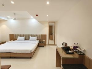 a bedroom with a large bed and a wooden table at HOTEL 11 JULY in Guwahati