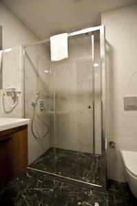 y baño con ducha y puerta de cristal. en VALİDE RESİDENCE en Estambul