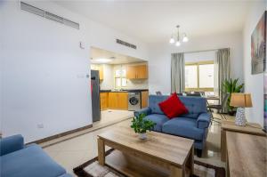 uma sala de estar com um sofá azul e uma mesa em RH- Experience Comfort and Convenience in our 2BR, Al Barsha em Dubai