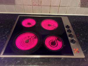 um fogão com quatro queimadores cor-de-rosa em cima em One Bedroom Flat/Apartment. em Bexleyheath