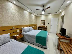 a hotel room with two beds and a television at Dublin Hotel in São Paulo
