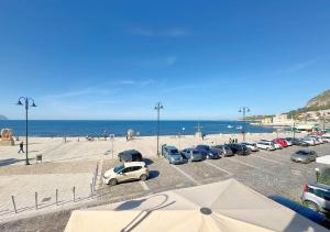 a parking lot with cars parked next to the beach at Solemar Sicilia - Casa Bella in Bagheria