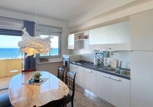 a kitchen with a table and a kitchen with the ocean at Solemar Sicilia - Casa Bella in Bagheria