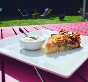 une assiette avec un morceau de gâteau et un bol de yaourt dans l'établissement La Sapinière, à Saint-Laurent-sur-Mer