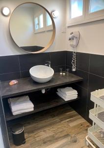 a bathroom with a sink and a mirror at La Sapinière in Saint-Laurent-sur-Mer