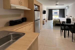 a kitchen with a sink and a dining room at Comfort Inn Centrepoint Motel in Lismore