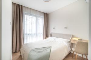 1 dormitorio con cama, escritorio y ventana en Golden Apartment Paupys, en Vilna