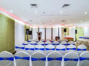 a conference room with white chairs and a podium at Zenith Smart Vacation Homes, Sharjah in Sharjah