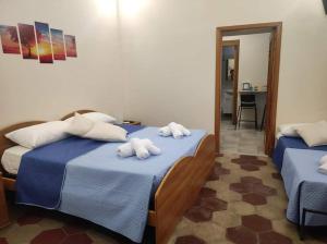 - une chambre avec 2 lits et des serviettes dans l'établissement La cassetta di Ninuccia, à Scafati