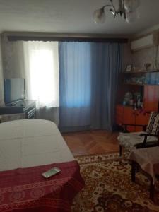 a bedroom with a bed and a chair and a window at 2-ух комнатная квартира in Baku