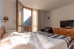a bedroom with a bed and a large window at Hotel Boka in Bovec