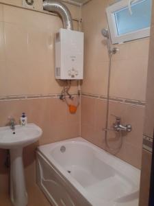 W łazience znajduje się prysznic, umywalka i wanna. w obiekcie 2-ух комнатная квартира w mieście Baku