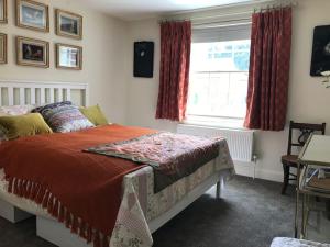a bedroom with a bed and a window at A gorgeous, two double bedroom, period cottage. in Brasted