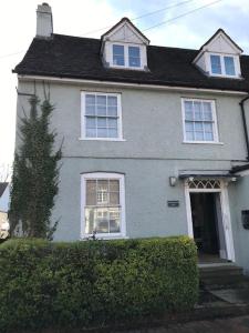 une maison blanche avec une haie devant elle dans l'établissement A gorgeous, two double bedroom, period cottage., à Brasted