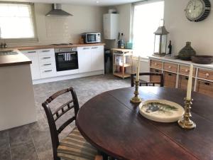 a kitchen with a wooden table with two candles on it at A gorgeous, two double bedroom, period cottage. in Brasted