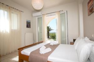 S&C Kosmos Beach Resort في رودا: غرفة نوم عليها سرير وفوط
