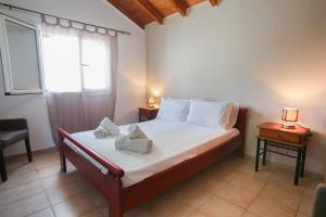 1 Schlafzimmer mit einem Bett mit einem Fenster und 2 Tischen in der Unterkunft S&C Kosmos Beach Resort in Roda
