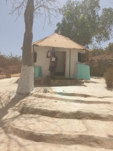 a man standing in front of a small house at Simple Life on Baobab Beach in Tanji +7 photos