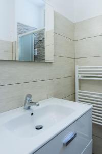 y baño con lavabo blanco y espejo. en Nonna Peppina Central Apartments, en Taormina