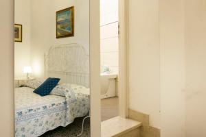 2 imágenes de un dormitorio con cama y espejo en Nonna Peppina Central Apartments, en Taormina