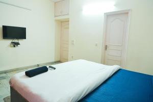 a bedroom with a large white bed with a television at Hotel Green Villa - Near Anand Vihar Railway Station in New Delhi