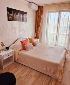 Un dormitorio con una cama grande y una ventana en Iaki Apartment Mamaia en Mamaia