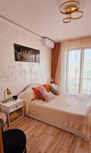 um quarto com uma cama grande e uma janela em Iaki Apartment Mamaia em Mamaia
