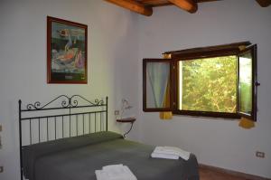 a bedroom with a bed and a window at agriturismo contrada del raglio in Potenza Picena