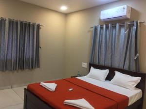 een slaapkamer met een bed met een rode deken bij Hotel Mint Leaf in Kāgal