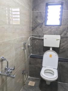 een badkamer met een toilet en een raam bij Hotel Mint Leaf in Kāgal