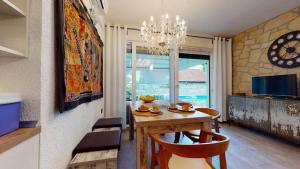 a dining room with a table and a chandelier at Carpe Diem Apartment in Ivan Dolac