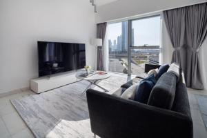 a living room with a couch and a tv at Frank Porter - Central Park Towers in Dubai