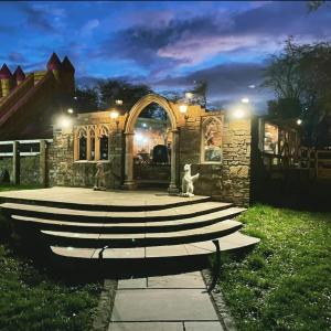 a stone house with an entry way at night at Burtree Country House and Retreat in Thirsk