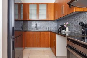 a kitchen with wooden cabinets and a stainless steel refrigerator at Frank Porter - Central Park Towers in Dubai