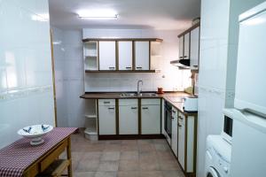 a small kitchen with white cabinets and a sink at Casa El Soldau in Naval